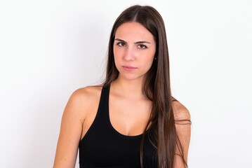 Fototapeta premium Young caucasian woman wearing sportswear over white background frowning his eyebrows being displeased with something.