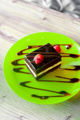 chocolate cake with strawberries on green plate