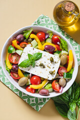 Classic Greek salad of fresh cucumber, tomato, sweet pepper, lettuce, red onion, feta cheese and olives with olive oil.