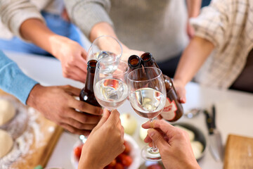 Close Up Of Friends Celebrating With Cheers At Home In Kitchen Making Food For Party