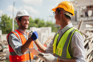 Engineers and workers shaking hands, congratulating success at work. Construction worker after...