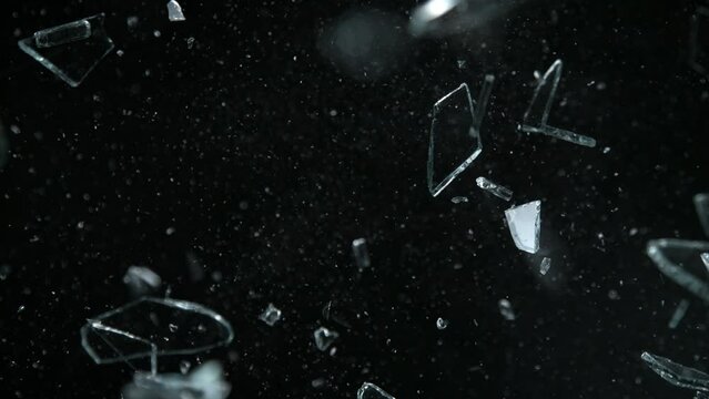 Super Slow Motion Shot of Shattering Glass Shards Flying Towards Camera on Black at 1000fps.