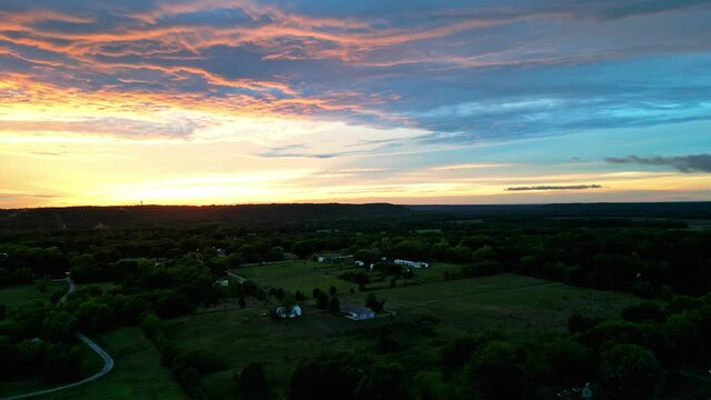 Aerial shot of the scenic village surrounded by trees at sunset