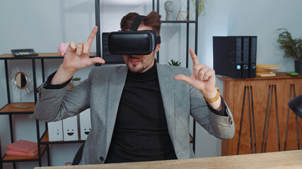 Businessman in suit working using virtual reality futuristic technology VR app headset helmet at home office. Freelancer man busy creating new architecture project. Remote education, study, learning
