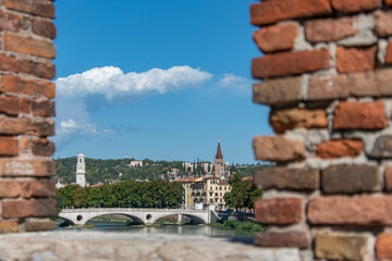 Blick durch ein Backsteinfenster auf den Fluss Etsch in Verona