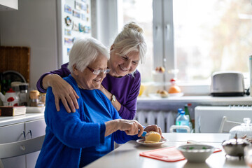 Woman spending time with her elderly mother at home
