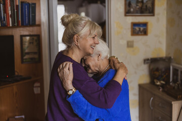 Woman hugging her elderly mother
