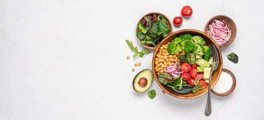 Healthy food in wooden bowl. Chickpeas, lettuce, cherry tomatoes, avocado, broccoli salad. Vegan...