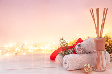 Christmas spa composition with incense sticks, towels and decor details.