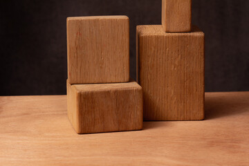 photogpaphy of a Parallelepiped wooden figures - still life on a wooden table on dark blurred background