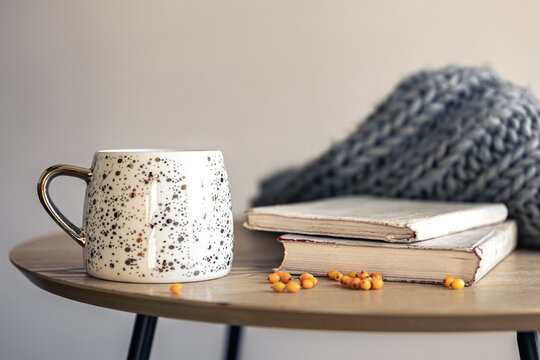 Home composition with a cup, a stack of books and a knitted element, copy space.