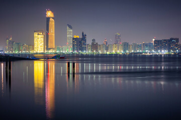 Fototapeta na wymiar Cityscape with skyscrapers of Abu Dhabi at night, capital of United Arab Emirates