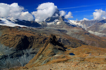 A landscape with a mountain Matterhorn view partially covered by clouds and two lakes at its foot, on a mountain Gornergrat, near Zermatt, in southern Switzerland
