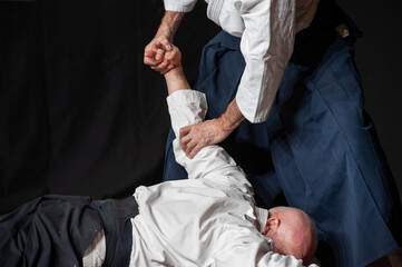 .Opponent knockdown and immobilization. Black belt aikido master during a training session. .