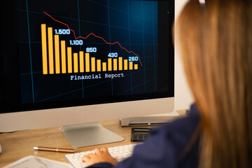 Businesswoman watches a financial report with falling revenue bar chart on the screen. Business data and financial figures on the screen. Trading, business, investment, sale and business data.