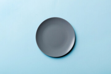Top view of isolated of colored background empty round gray plate for food. Empty dish with space for your design