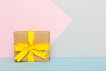 holiday paper present tied yellow ribbon bow top view with copy space. Flat lay holiday background. Birthday or christmas present. Christmas gift box concept with copy space