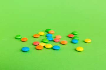 Pile of delicious colorful sweet candies on colored background top view. Confectionery decor