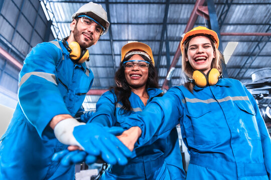 Young people worker in protective uniform operating machine at factory Industrial.People working in industry.Portrait of Female Engineer looking camera at work place.