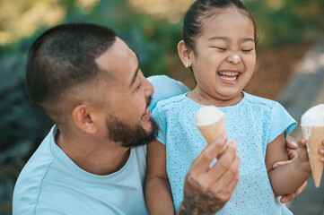 Young dad and his daughter eating ice-cream and looking enjoyed
