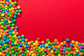 Mixed collection of colorful candy, on colored background. Flat lay, top view. frame of colorful chocolate coated candy