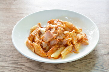 penne pasta topping pork bologna dressing fried chop pork in ketchup and cheese sauce on plate   