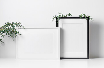 Picture frames mockup in white room with natural eucalyptus twigs