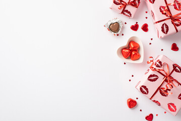 Valentine's Day concept. Top view photo of large present boxes in wrapping paper with kiss lips pattern plate with heart shaped chocolate candies confetti on isolated white background with empty space