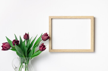 Landscape frame mockup on white wall with tulips