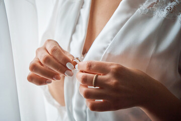 The bride gently holds the wedding ring with beautifully manicured fingers. Wedding. Close-up.