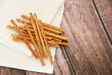dry long baked bread sesame sticks on a wooden background
