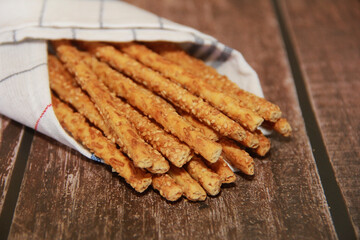 dry long baked bread sesame sticks on a wooden background