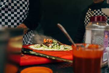 men in checkered apron preparing street food