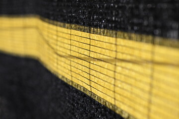 Side view to a yellow black visual and dust protection foil on a site fence of a construction site...