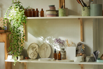 Background image of handmade ceramics on shelf in cozy workshop lit by sunlight