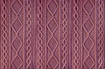 pink background knitted fabric with a pattern. Knitted Arans close-up