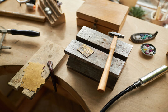 Top view background image of tools on jewelers workstation in cozy studio, copy space