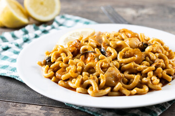 Traditional Spanish fideua on wooden table. Noodle paella 