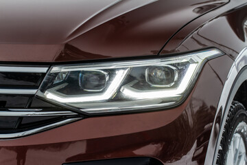 Headlight lamp of new cars. Close up detail on one of the LED headlights modern car. Exterior closeup detail. Closeup headlights of car.