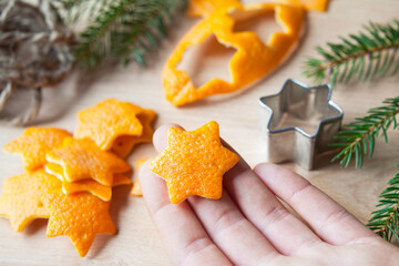 Zero waste handmade Christmas decor  - a craft made by cutting in star shape the scrap orange peel. Once they dry can be used as ornaments to decorate a Christmas tree.
