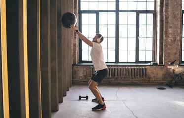 Fototapeta na wymiar Man in sportswear exercising with ball