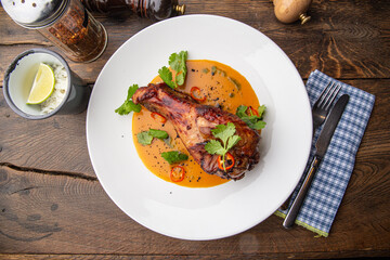 Baked chicken drumstick with sauce and herbs