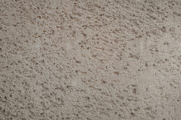 abstract background of an old embossed concrete beige wall close up