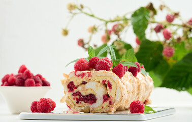 Baked meringue roll with raspberries. Whipped egg whites and buttercream, delicious dessert