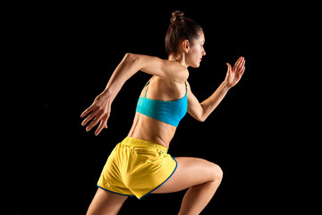 Young sportive woman, runner and jogger in motion action isolated on black background. Sport,...