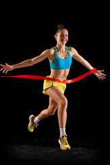 Winner, champion at finish line. Young fitness sportive girl in sports uniform running, training...