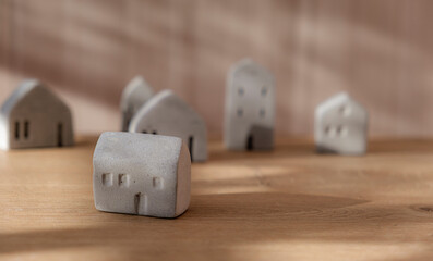 Miniature concrete house. Minimal house mockup on wooden floor.
