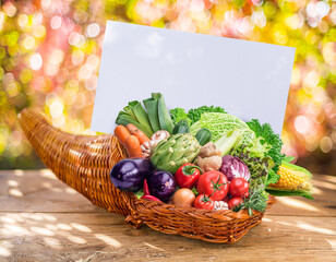 Horn of plenty with fresh organic vegetables and herbs as a symbol of autumn gifts. Blurred...