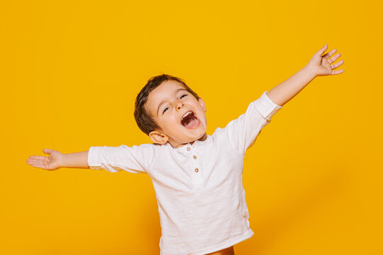 Naklejki Excited little boy raising arms