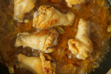 cooking chicken curry in a cooking pan 
